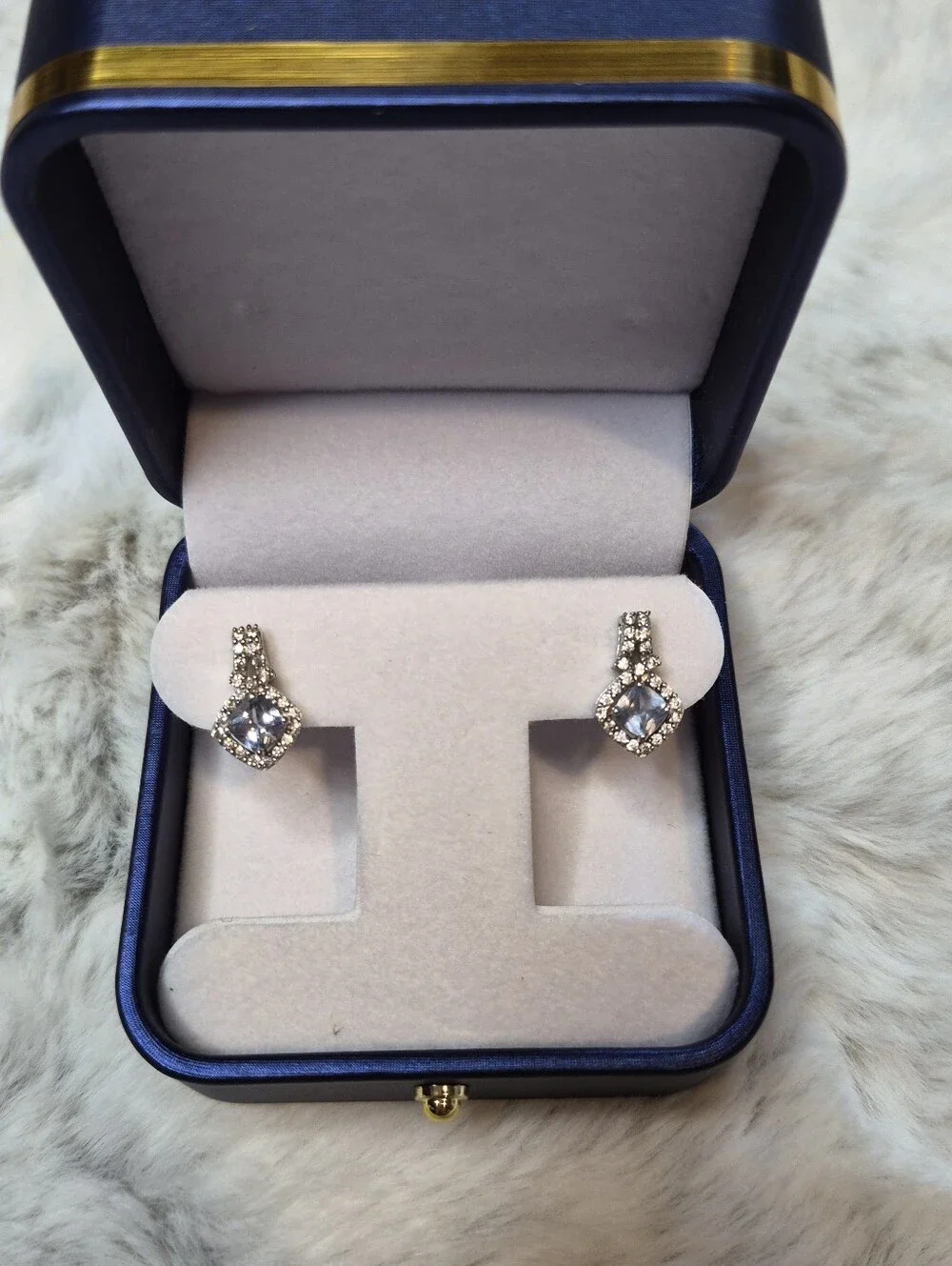 Brighton drop earrings feature a striking cushion-cut blue crystal center
